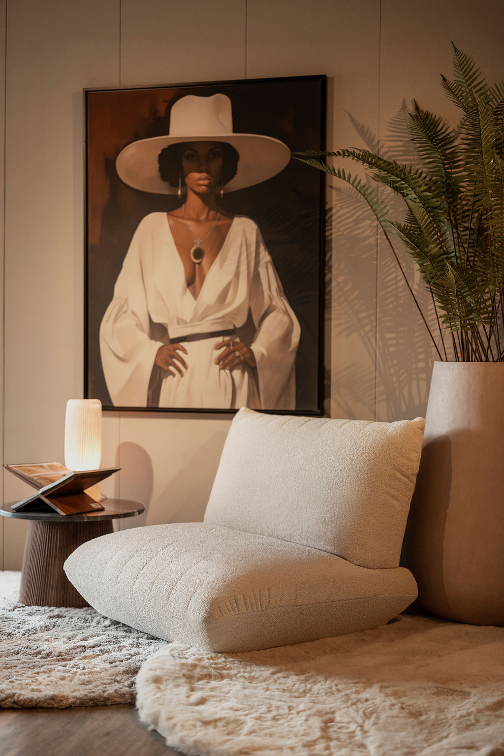 Sfeerhoek in de showroom met fauteuil, kunst en bijzettafel